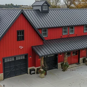 30x70 Barndominium that is red colored with a black roof. The home is sitting on a green lawn in the midwest of America.